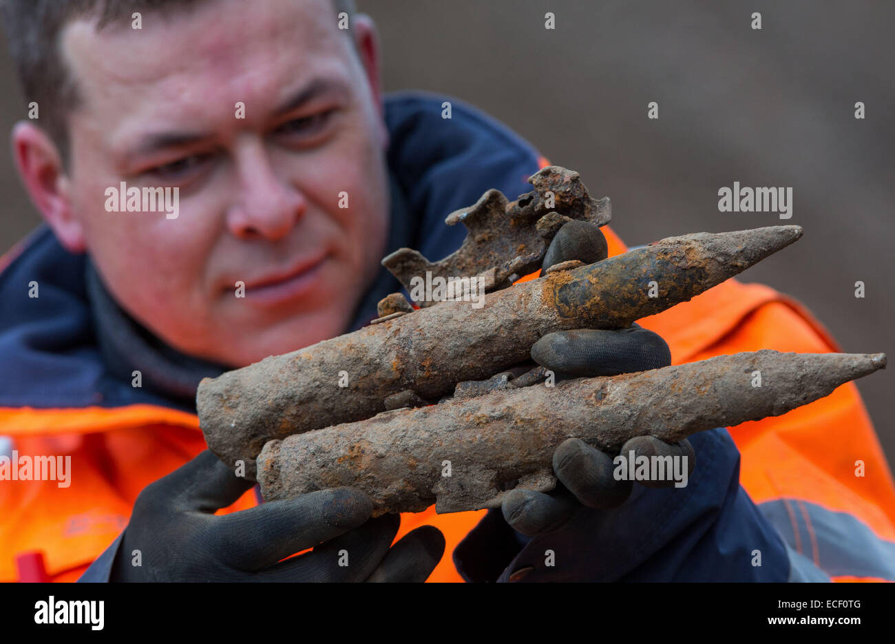 Schwerin, Germany. 09th Dec, 2014. Munitions excavator Maik Rohde looks at munician casing at the planned expansion area of the Technology and Commercial Center (TGZ) in Schwerin, Germany, 09 December 2014. Since the end of August, there has been an intensive search for traces of the military past. Around 16 tons of infantry munitions, grenades, mines and tank busting weapons have been recovered from the seven hectare grounds. In East Germany, the Soviet Union armed forces used the grounds. Photo: JENS BUETTNER/dpa/Alamy Live News Stock Photo