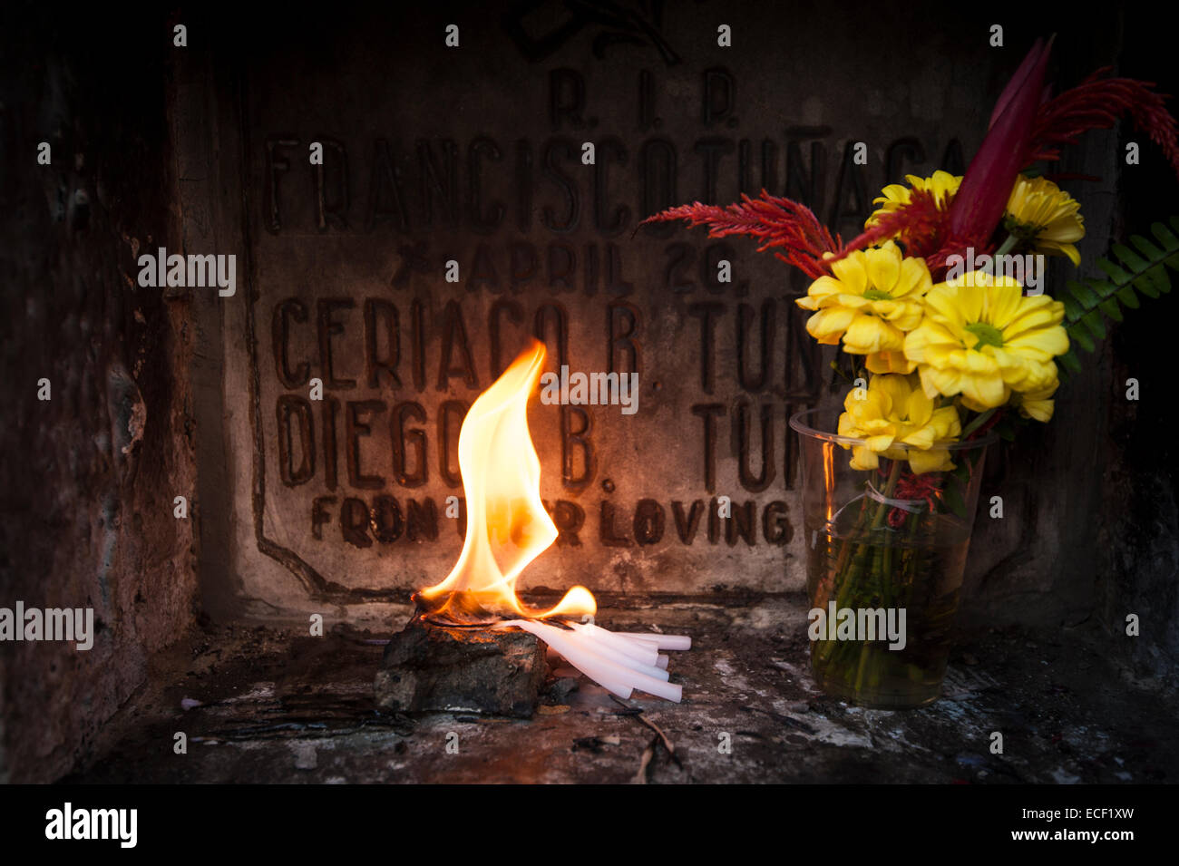 Flame and flowers at a tomb Stock Photo