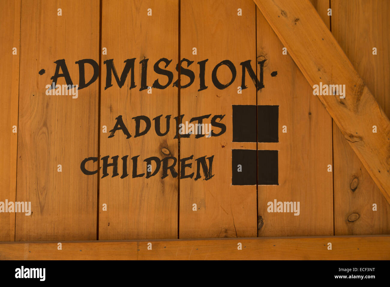 A photograph of an admission sign for adults and children on a timber door background. Stock Photo