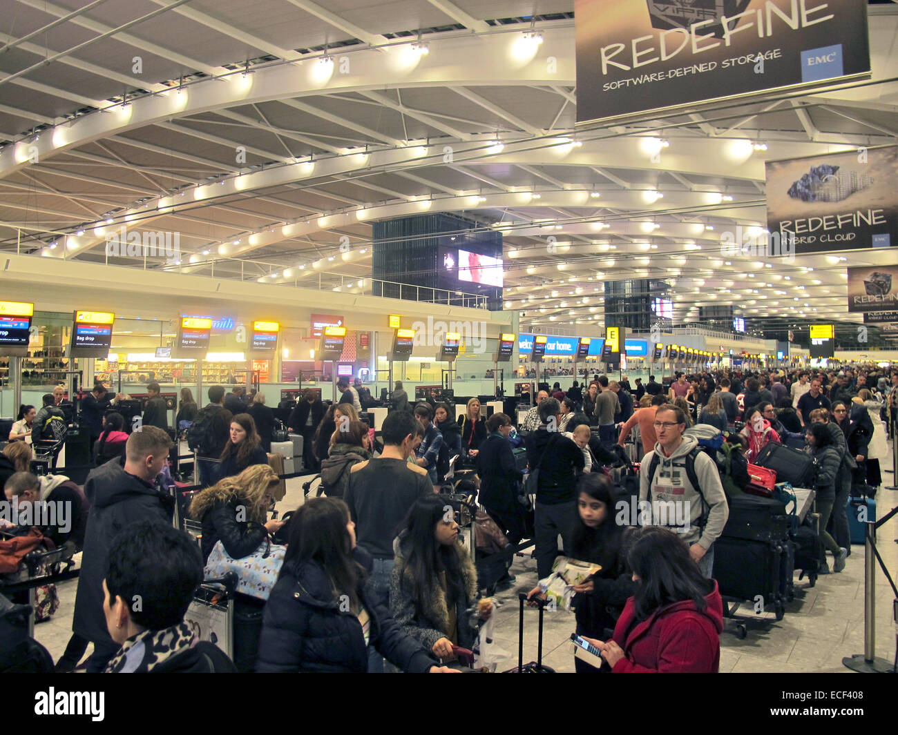 Passangers stand in line waiting to check in at Heathrow airport ...