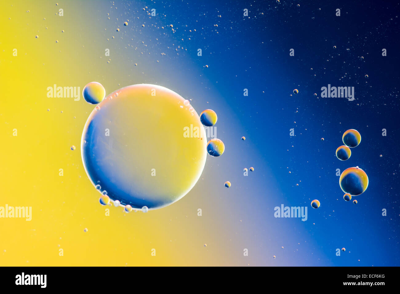 Abstract macro with oil drops in water, looking like planets in space. Stock Photo