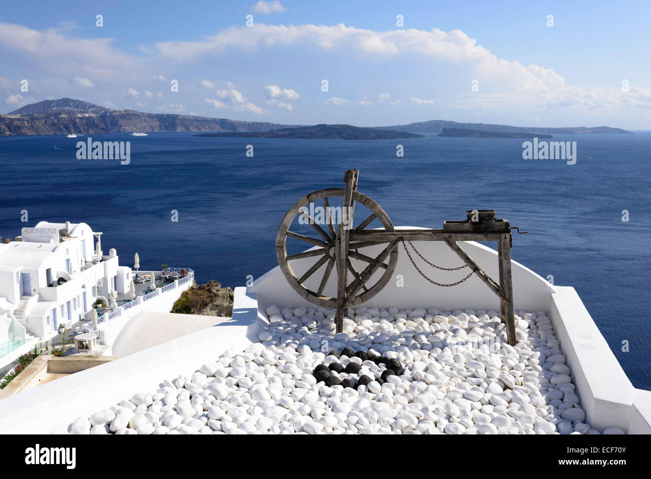 Old wooden spinning wheel with a view of the Caldera in background Oia