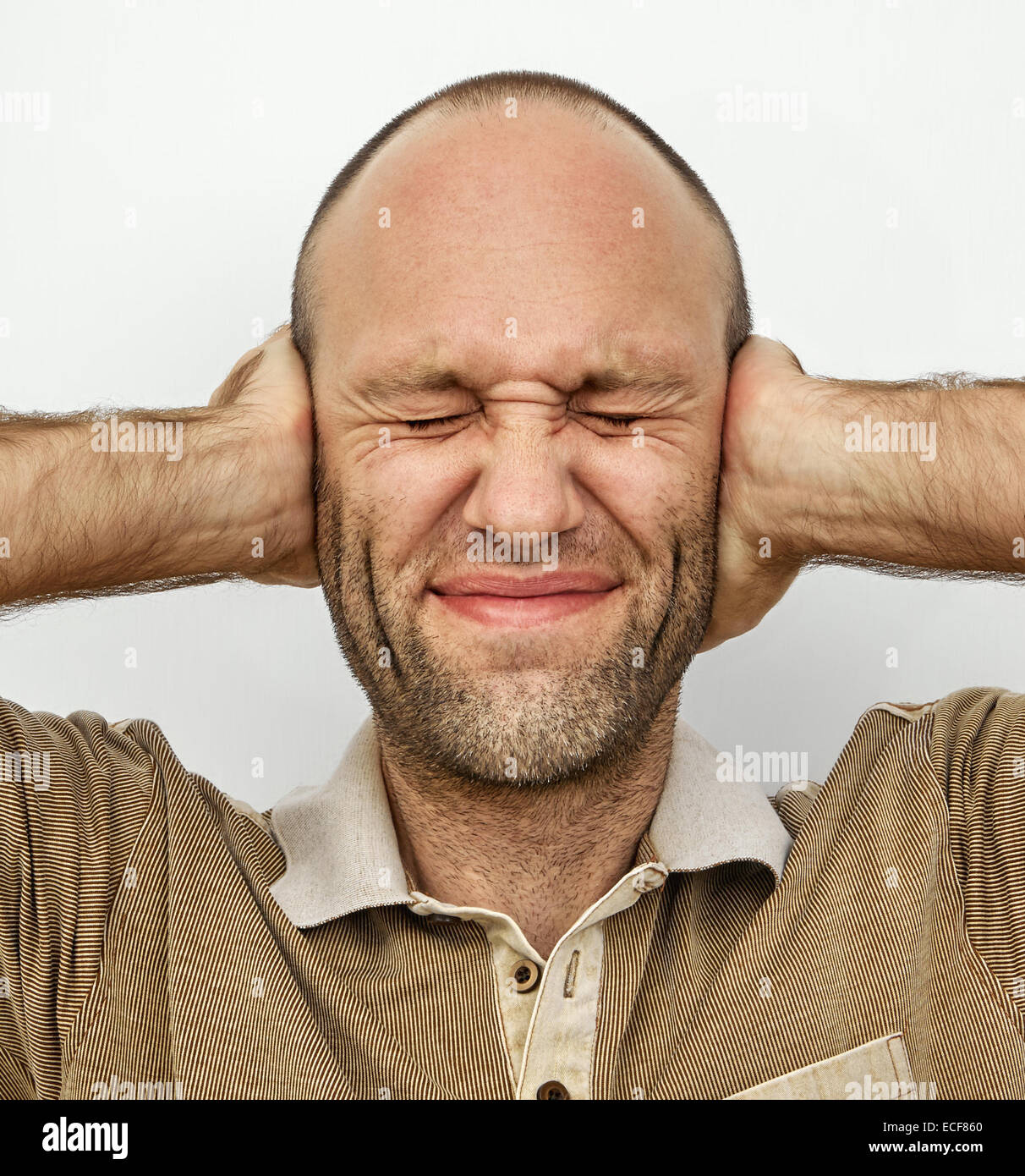Man with eyes and ears tightly closed with hands Stock Photo Alamy