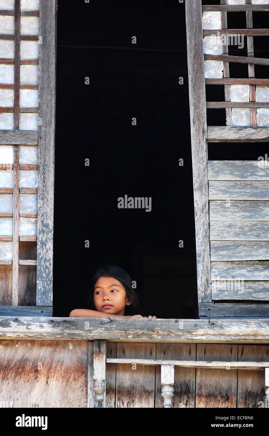 Child in old capiz shell window Stock Photo