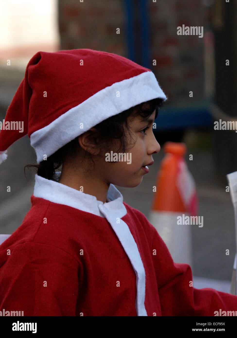 Young girl in a Santa suit at the Padstow Christmas festival, Cornwall, UK Stock Photo