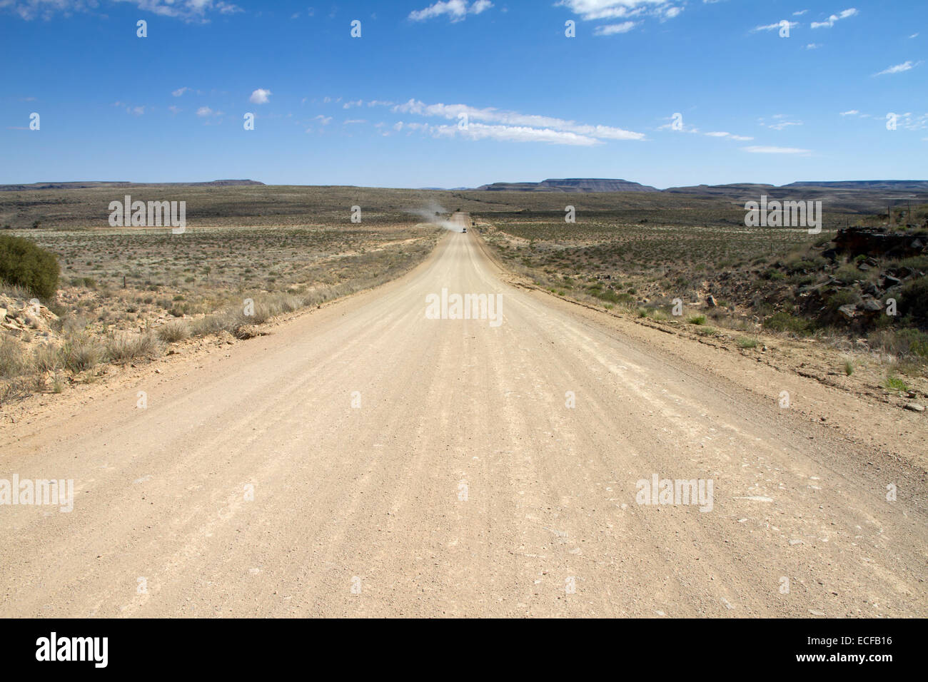 A namibian dirt road wit a far away 4x4 travelling Stock Photo