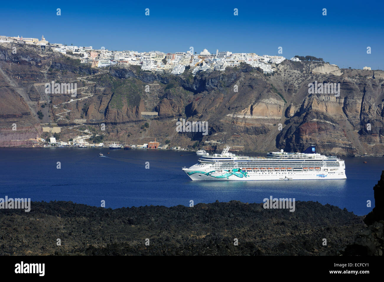 Cruise liner Norwegian Jade below cliffs and white houses, Santorini, Greece Stock Photo