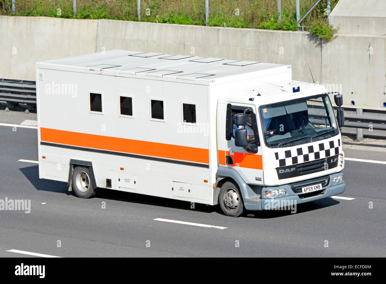 Unmarked Daf prison van lorry truck (assumption based on windows, markings and roof hatches) driving along English motorway Stock Photo