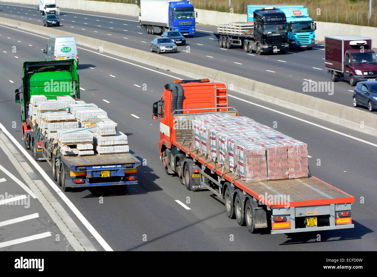 Two hgv articulated flatbed trailer lorries loaded with building