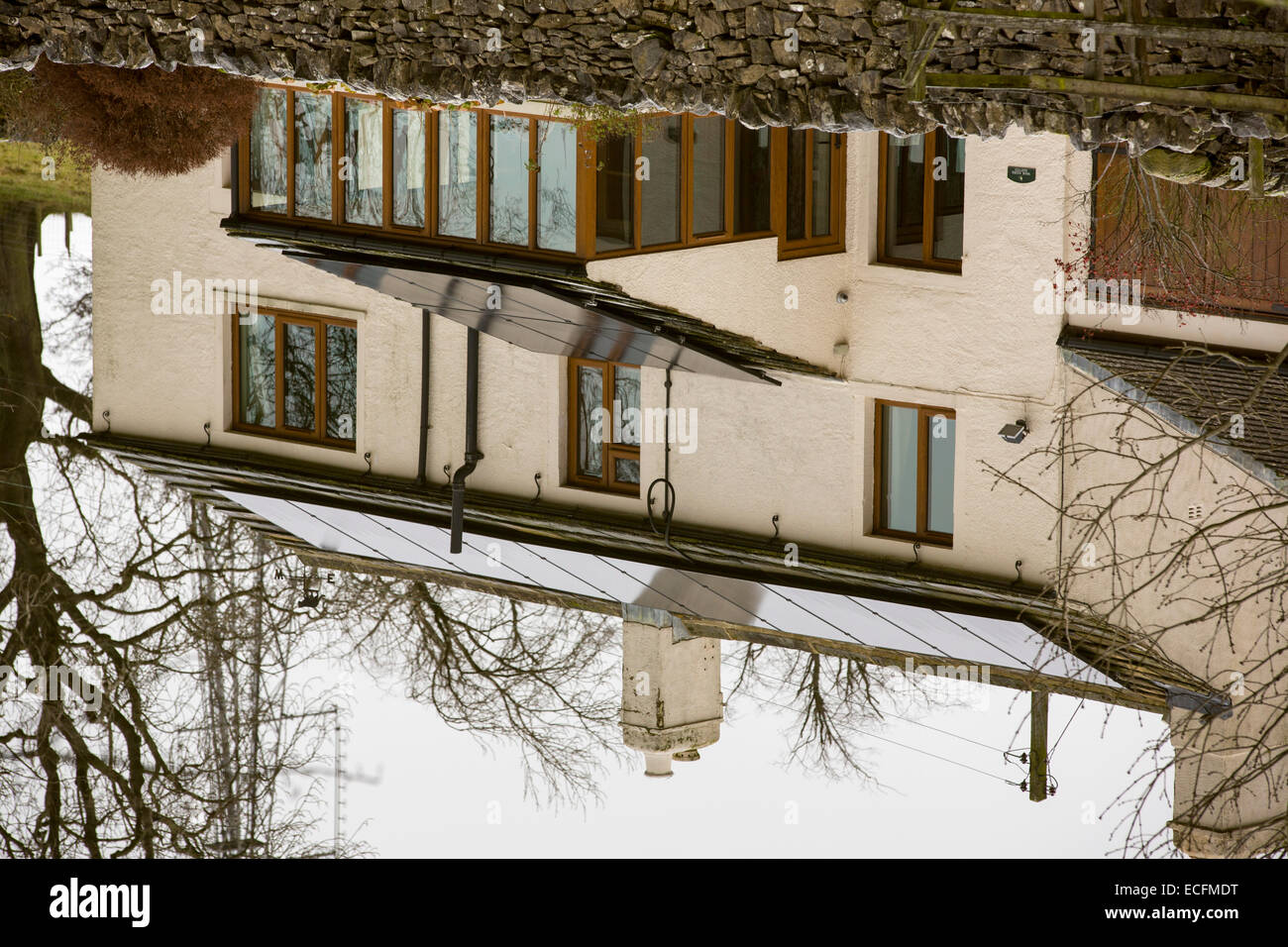 Solar panels on a house roof reflected in the Leeds Liverpool canal near Skipton, UK. Stock Photo