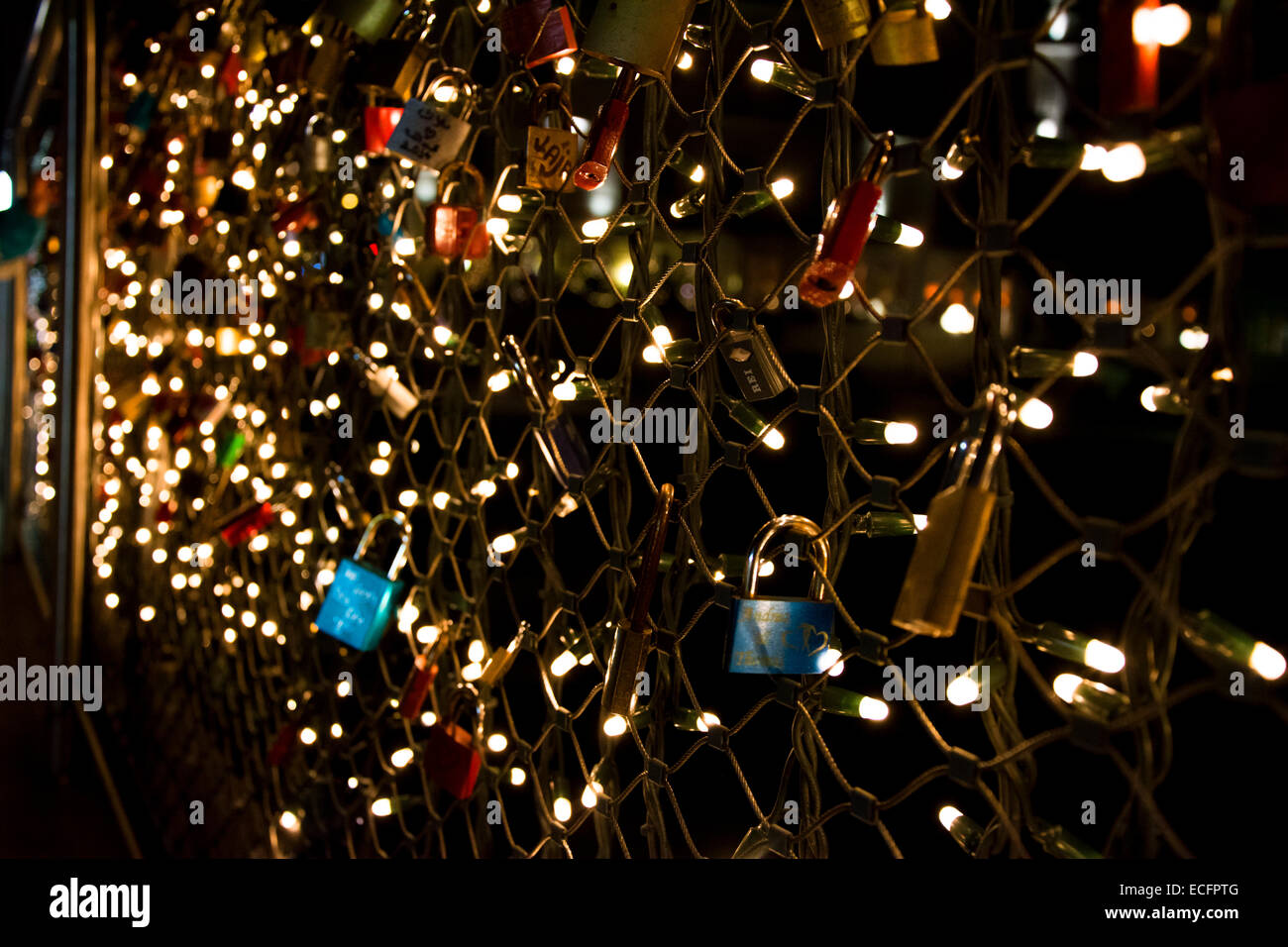 Love padlocks locked on Makartsteg bridge in Salzburg with lights in the night Stock Photo