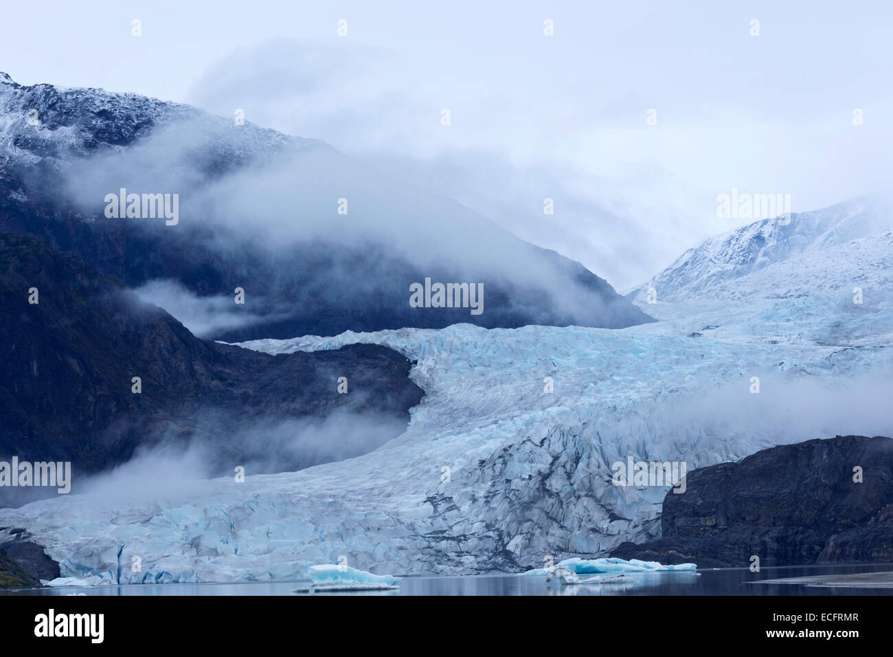 Misty hues of blue of the receding tongue of the Mendenhall Glacier and its ice melt lake in Juneau, Alaska. Stock Photo
