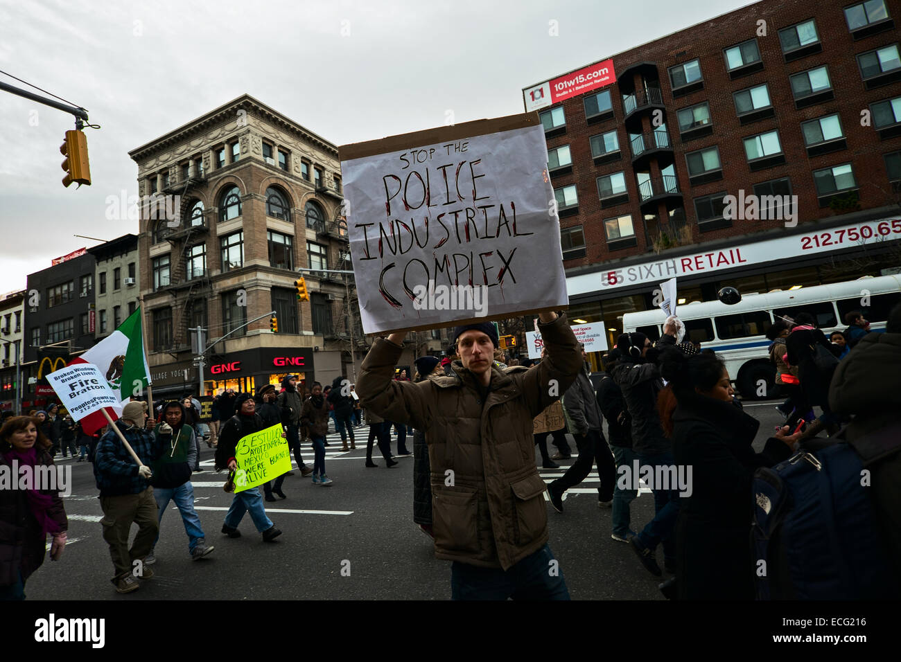 New York, USA. 13th December, 2014. A man holding a sign reading, 'Stop the police industrial complex!' was one of thousands of people who marched along New York City streets to protest against police violence against blacks. Credit:  Joseph Reid/Alamy Live News Stock Photo