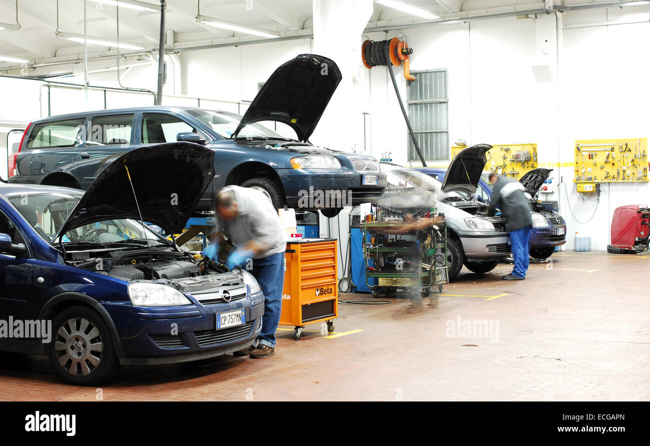 Mechanic in repair garage checking car's engine covering car with a ...