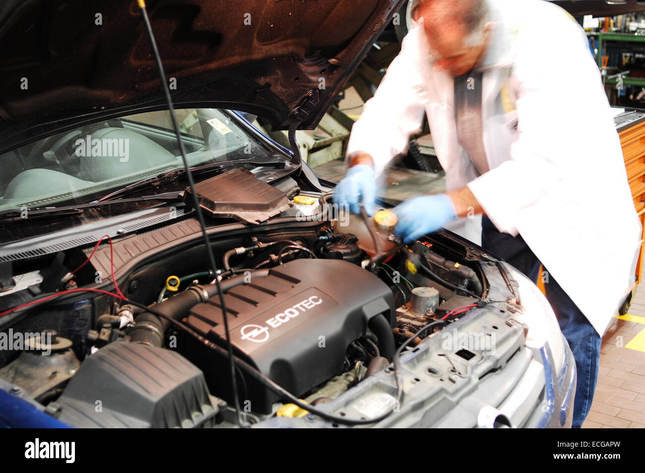 Mechanic in repair garage checking car's engine covering car with a ...
