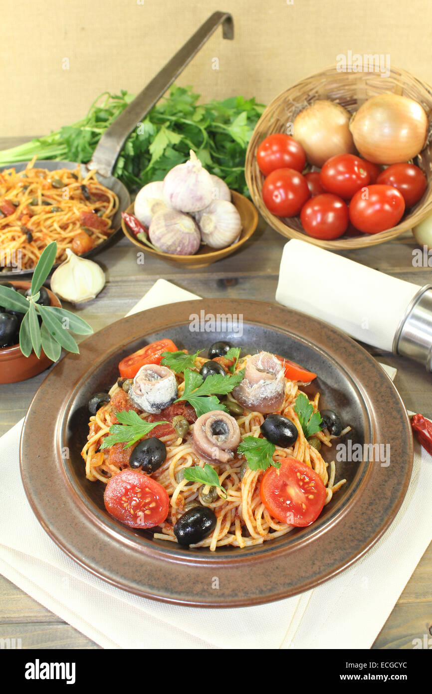 a plate of pasta, olives, tomatoes, anchovies and capers Stock Photo