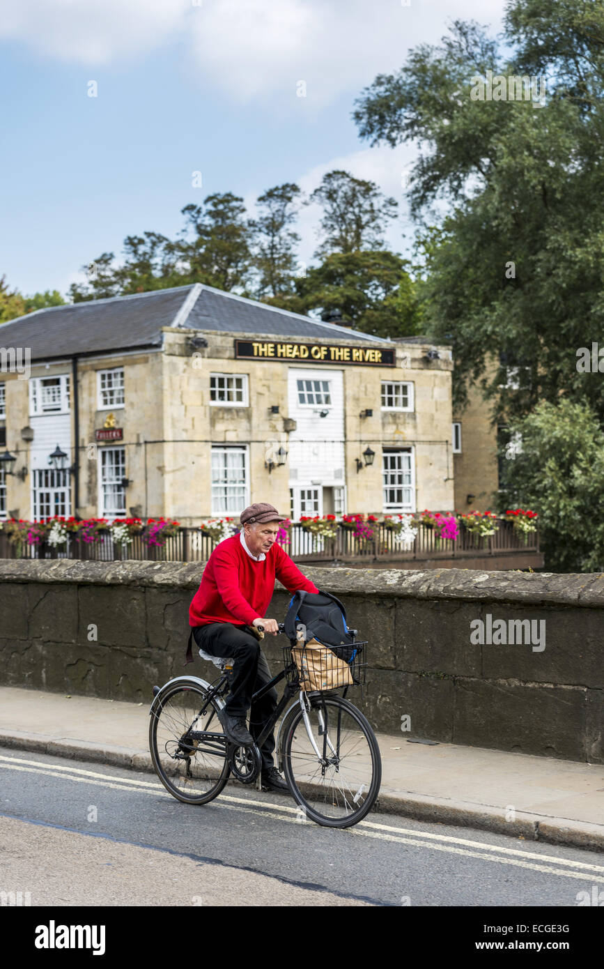 A man cycles over Folly Bridge on the Abingdon Road in Oxford with the famous pub The Head of the River behind him Stock Photo