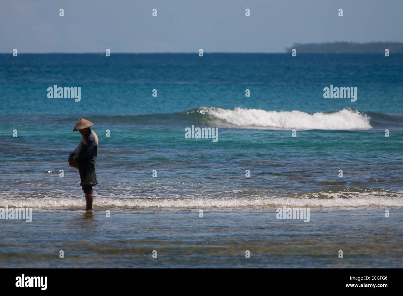 A fisherman preparing fishing net to fish on the coastal water of Tanjung Setia beach in Krui, Pesisir Barat, Lampung, Indonesia. Stock Photo