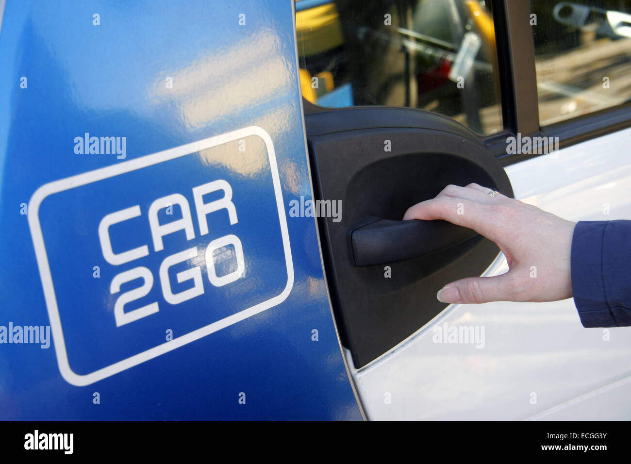 Woman operning door handle to CAR 2 GO Car club vehcile Stock Photo