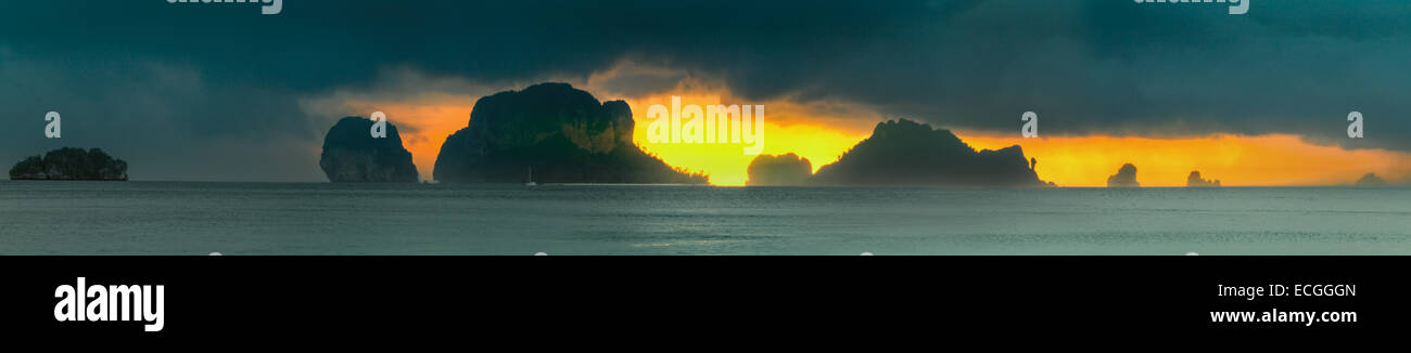 Dramatic sunset rays through a cloudy dark sky and mountains over the ...