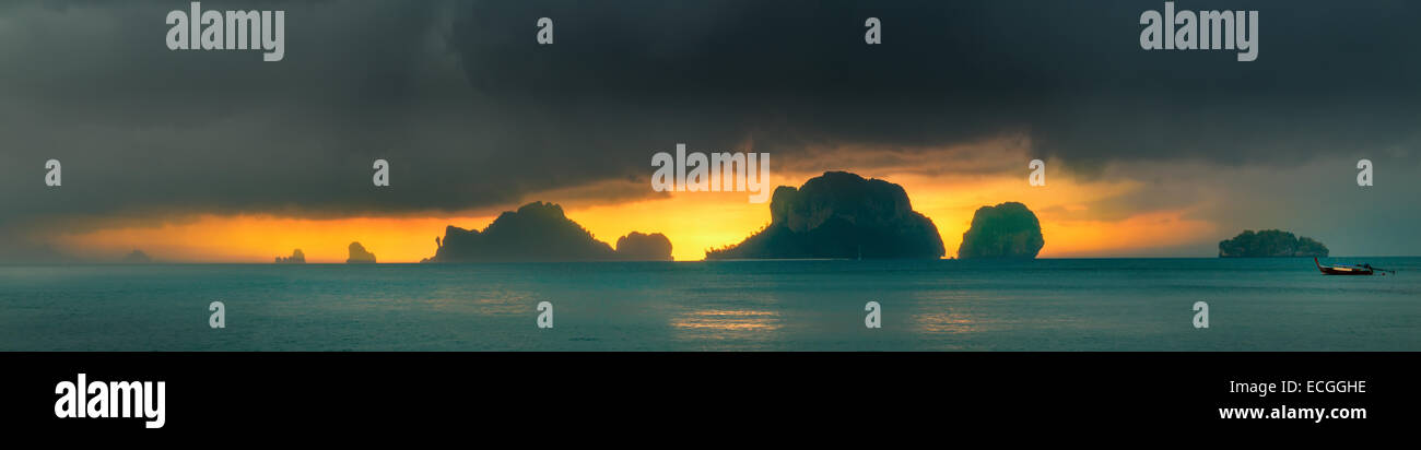 Dramatic sunset rays through a cloudy dark sky and mountains over the ...