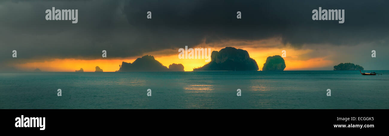 Dramatic sunset rays through a cloudy dark sky and mountains over the ...