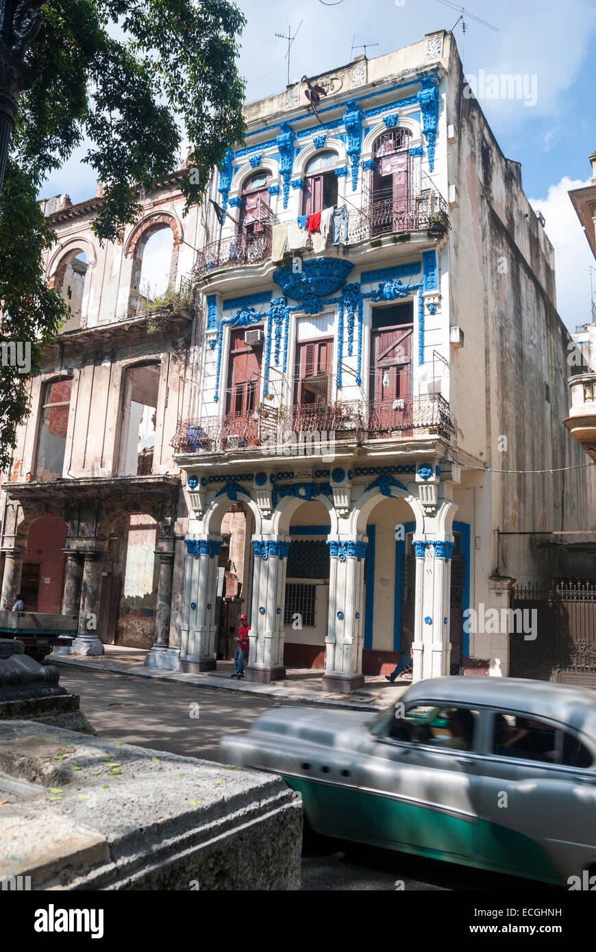 A vintage American automobile passes a colourful Colonial inspired apartment building on the Prado in downtown Havana Stock Photo