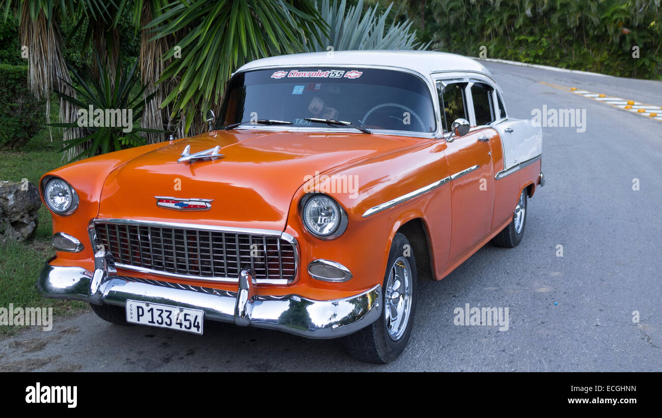 An old 1955 American Chevrolet commonly used as a taxi for tourists is parked outside a resort in Cuba Stock Photo