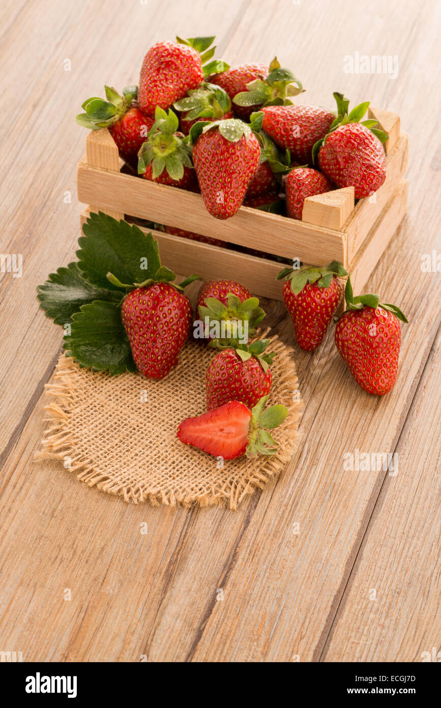 Strawberries over odl brown wooden table background Stock Photo - Alamy