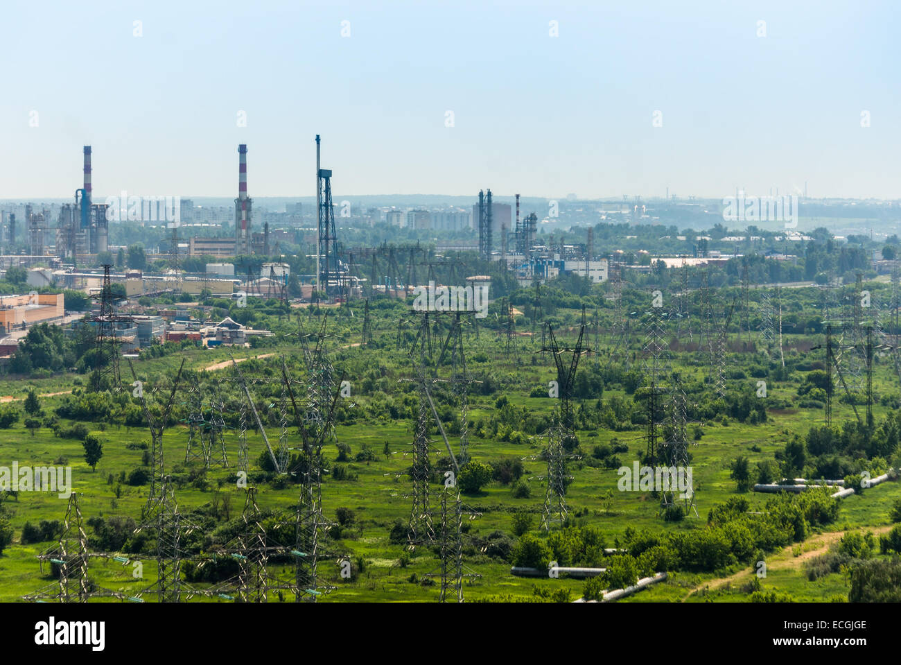 A lot of electric lines with refinery in the background Stock Photo