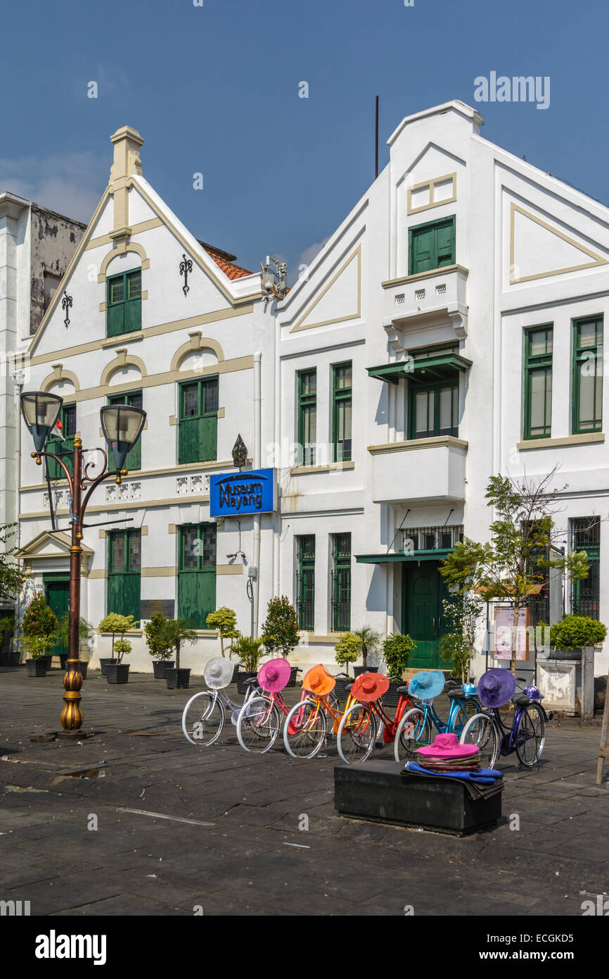 Colorful rental bikes with matching hats in front of the Wayang Museum at Fatahillah Square, Jakarta, Indonesia. Stock Photo