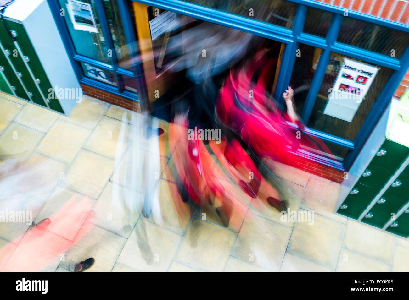 Secondary education, Wales UK - motion blurred image of pupils streaming rushing out of school going home at the end of the school day Stock Photo