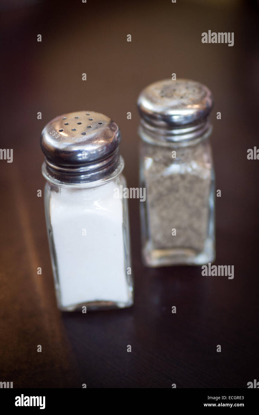 Classic clear salt and pepper shakers (pots).  Selective focus on the salt shaker (pot). Stock Photo