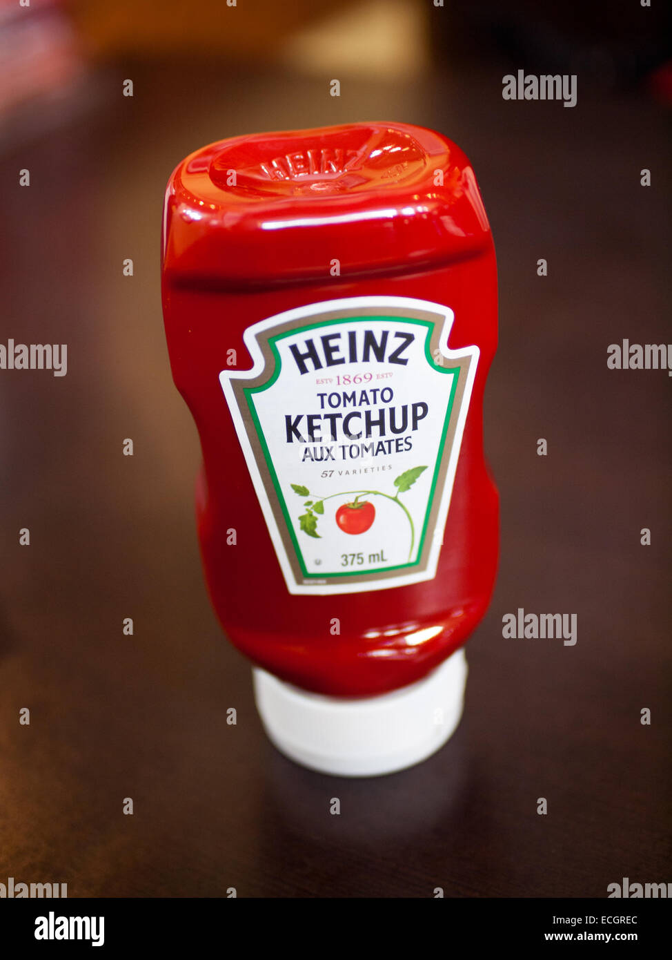 An upside-down Heinz Tomato Ketchup bottle. Canadian packaging with French and English labels is shown. Stock Photo