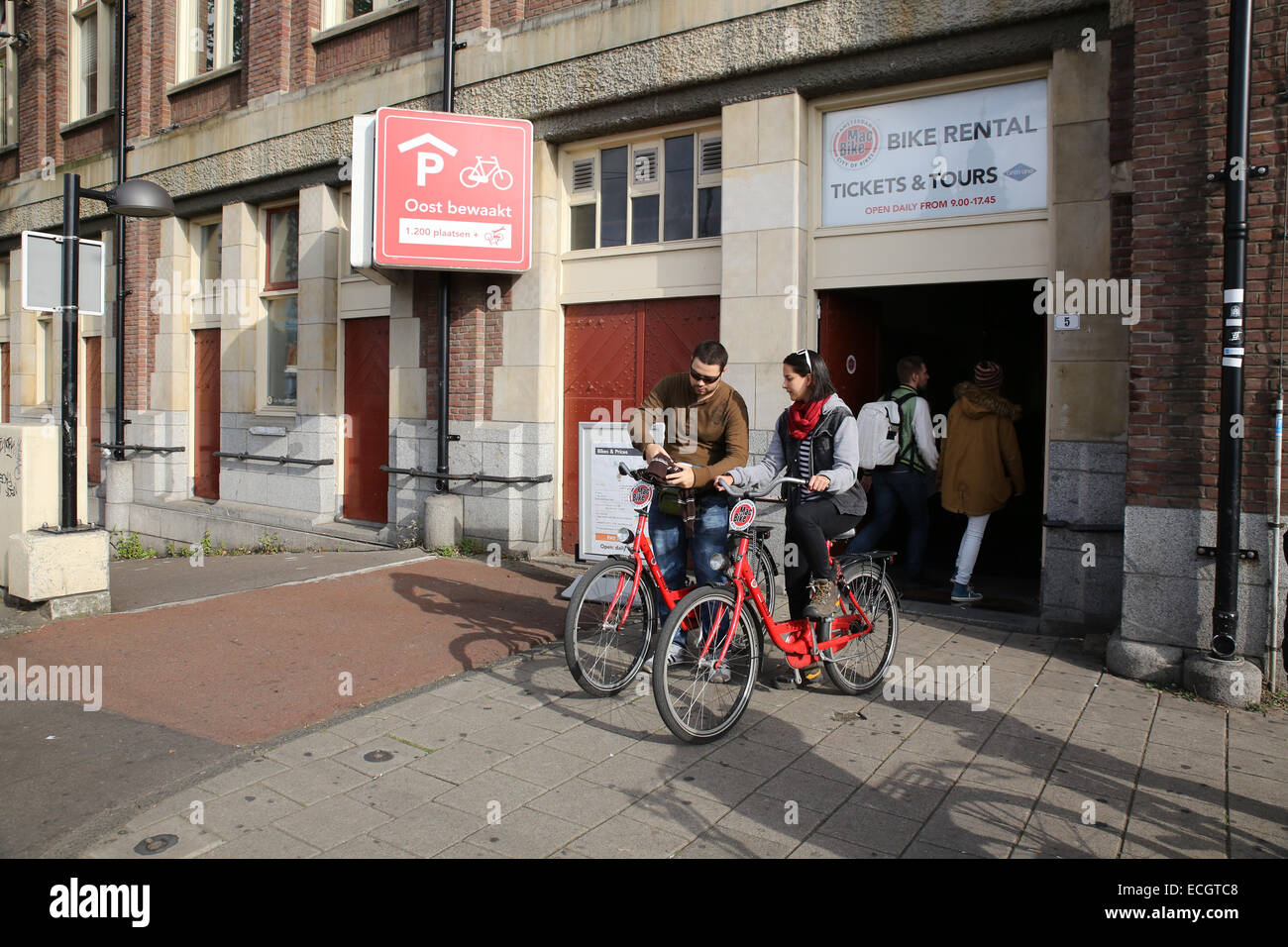 man woman renting bike amsterdam bicycle rental Stock Photo