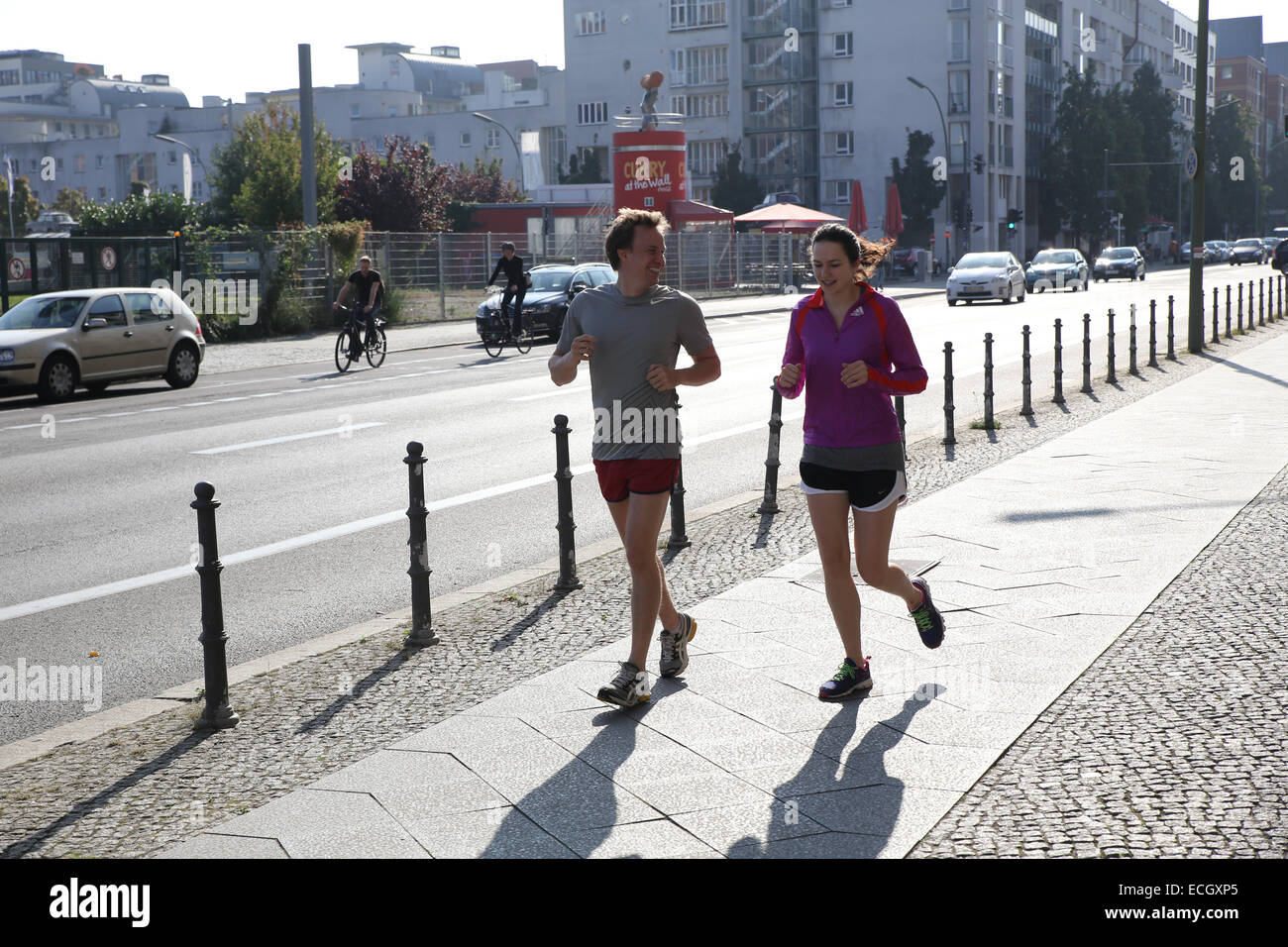 man woman running city street berlin Stock Photo