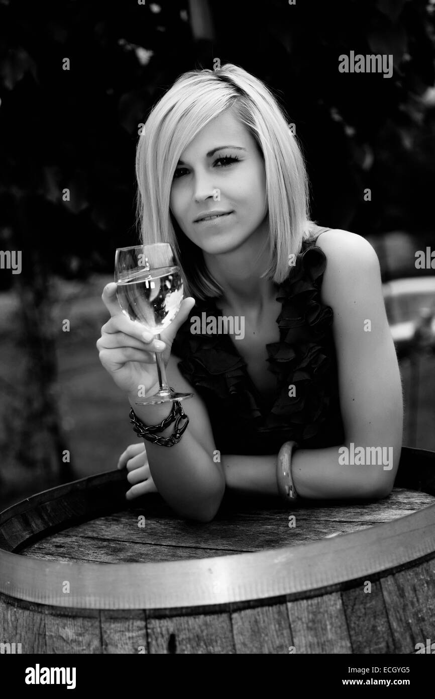 beautiful young woman with glass of wine standing at wine cask Stock ...