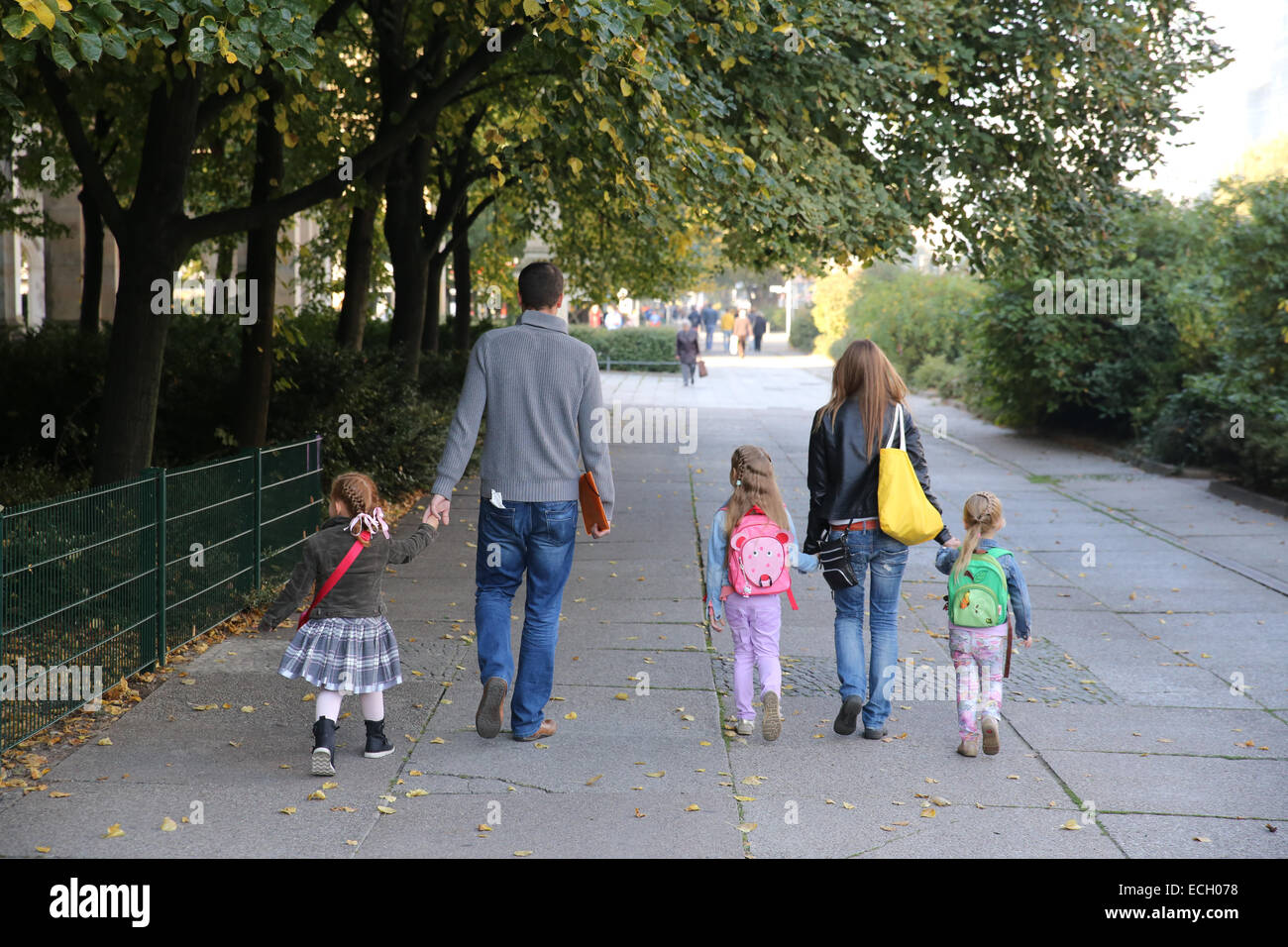 family five dad mom daughter walking street europe hold hands Stock Photo