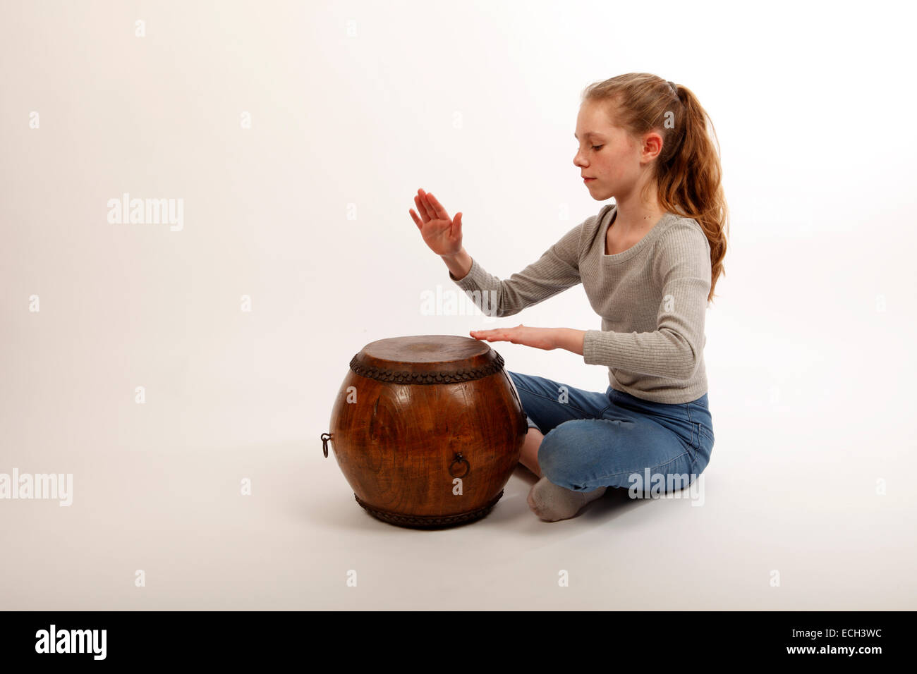 young girl playing a hand drum, a chinese double headed tom tom Stock Photo