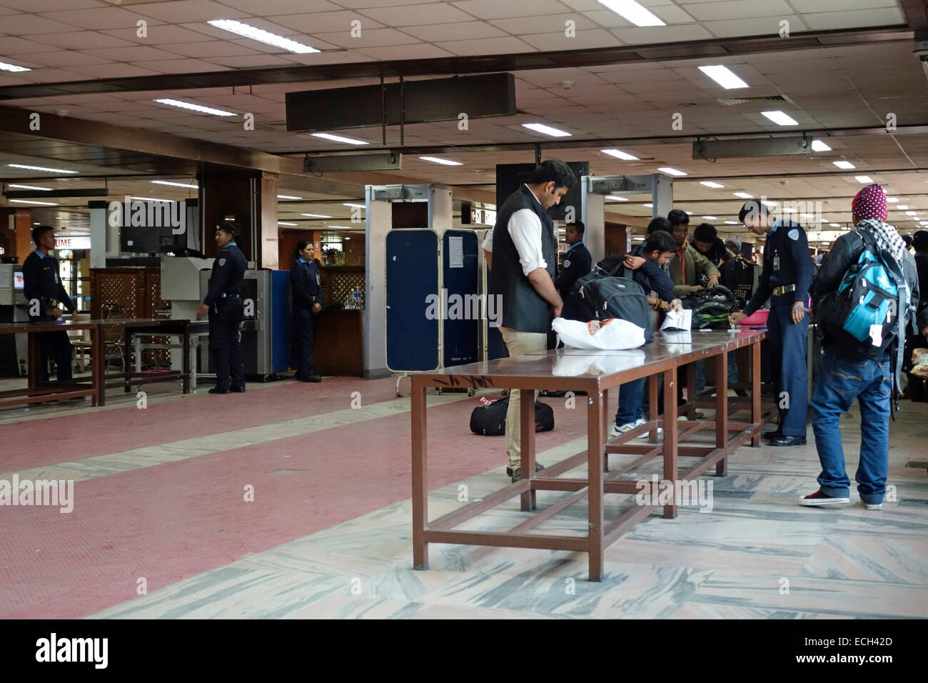 Security agents check passengers belongings at the departure hall of Tribhuvan International airport in Kathmandu Nepal Stock Photo