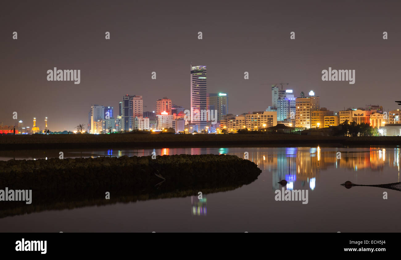Night city skyline, shining lights and reflections in water. Manama, the Capital of Bahrain Kingdom, Middle East Stock Photo