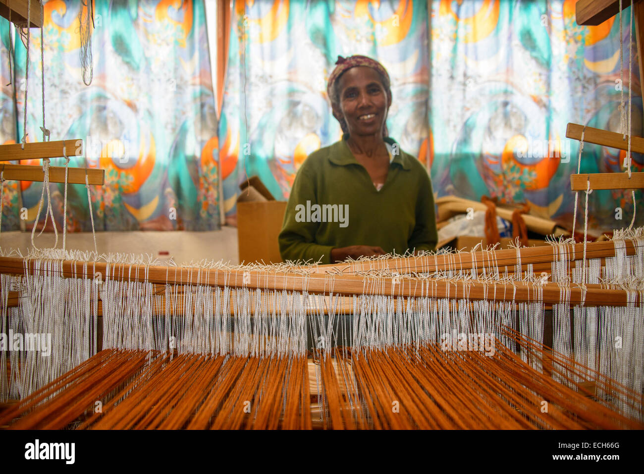 Friendly woman working on a hand weaving loom on social project, Eritrea Stock Photo