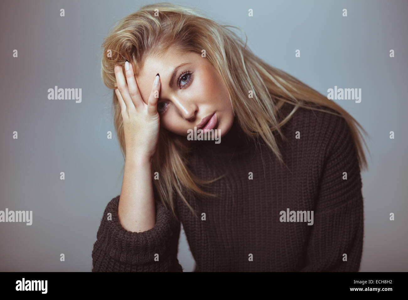 Contemplative woman in sweater. Pretty young woman looking serious. Stock Photo