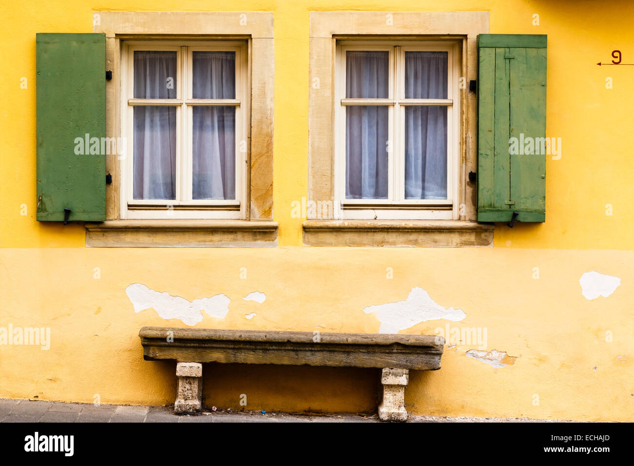 Close up of windows and bench seat, yellow house, Rothenburg ob der Tauber Stock Photo