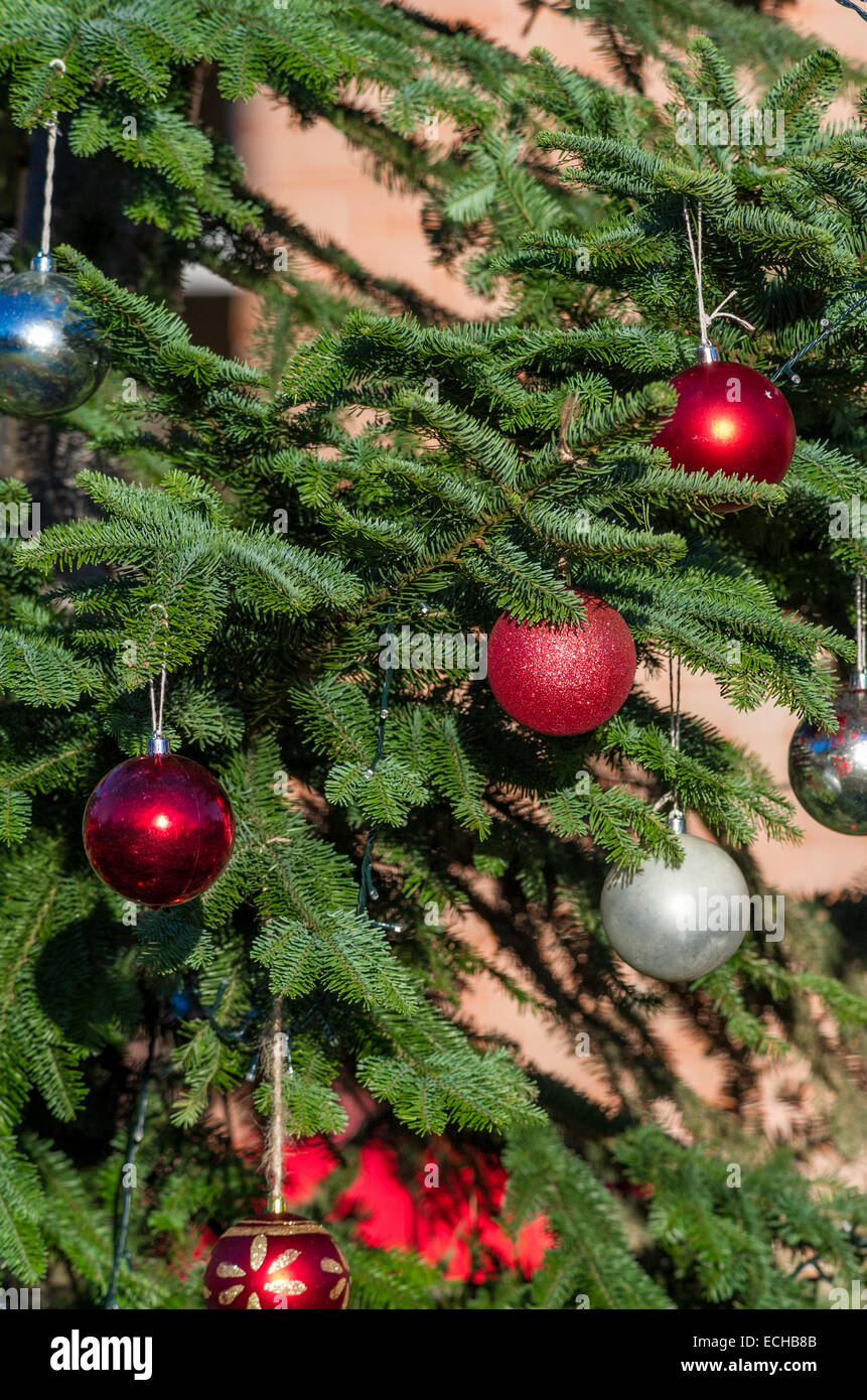Christmas tree placed outside decorated with baubles. Stock Photo