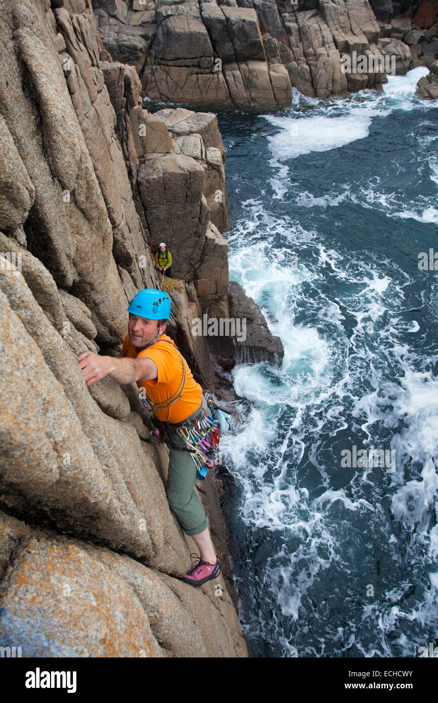 Iain Millar - a professional mountain guide - rock climbing up a sea stack near Gweedore, County Donegal, Ireland. Stock Photo