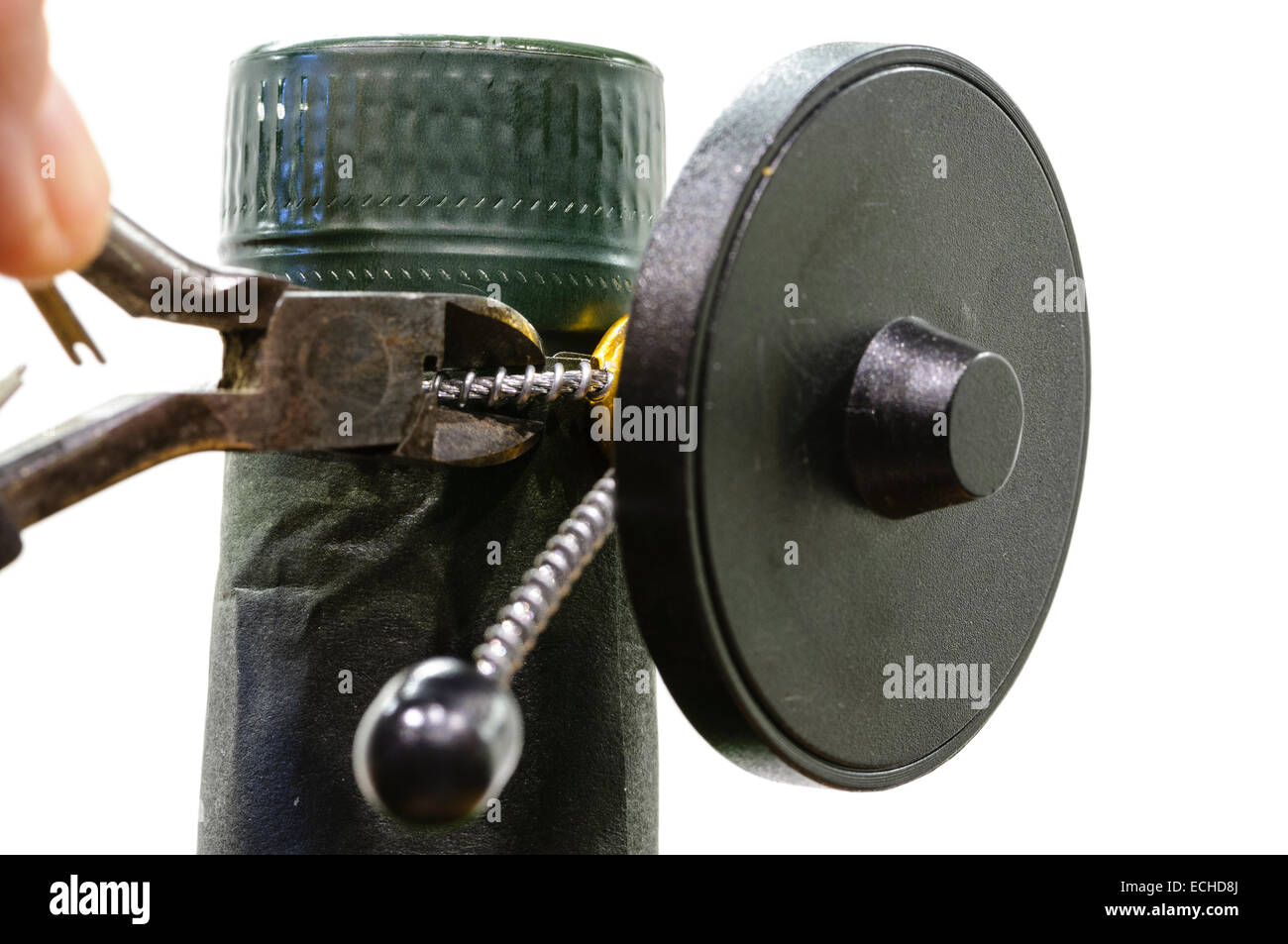 Person uses wire cutters to remove the security tag from a bottle of  alcohol Stock Photo - Alamy