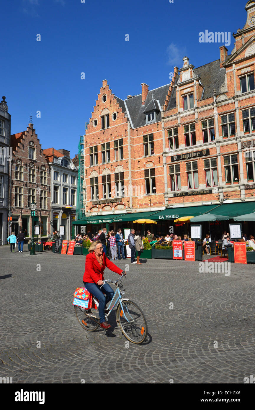 Woman Riding a Bike in the Market Square Bruges Belgium EU Stock Photo