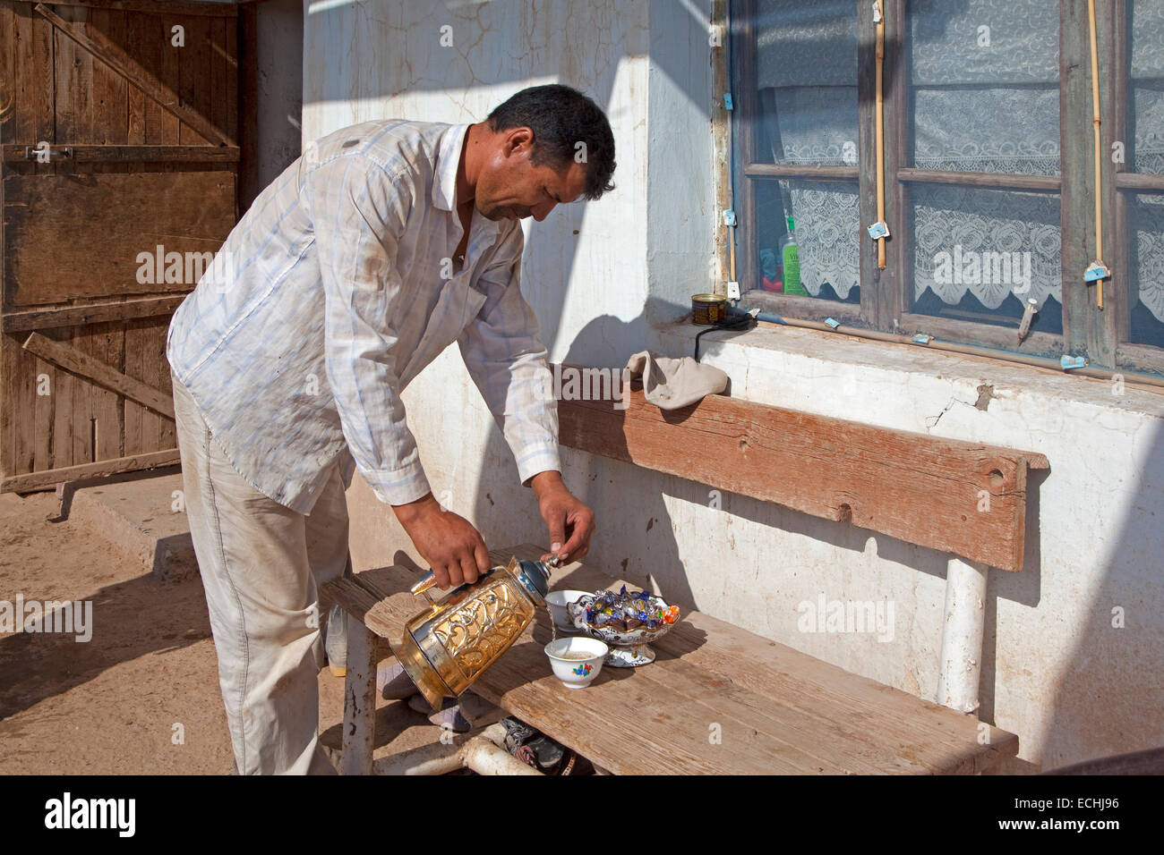 Turkmen farmer pouring out tea from a traditional teapot, Turkmenistan Stock Photo