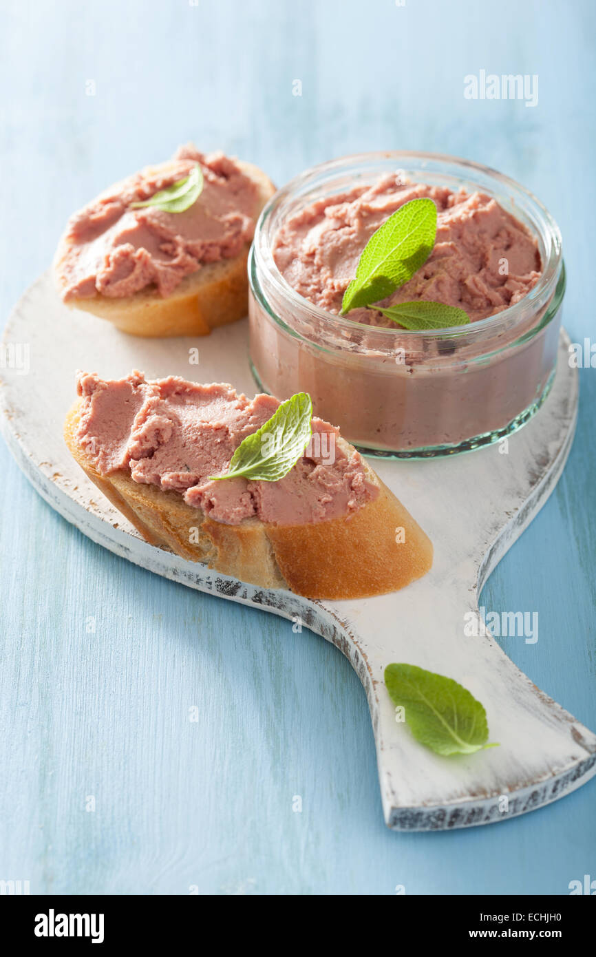 healthy chicken liver pate with sage in jar and on bread Stock Photo